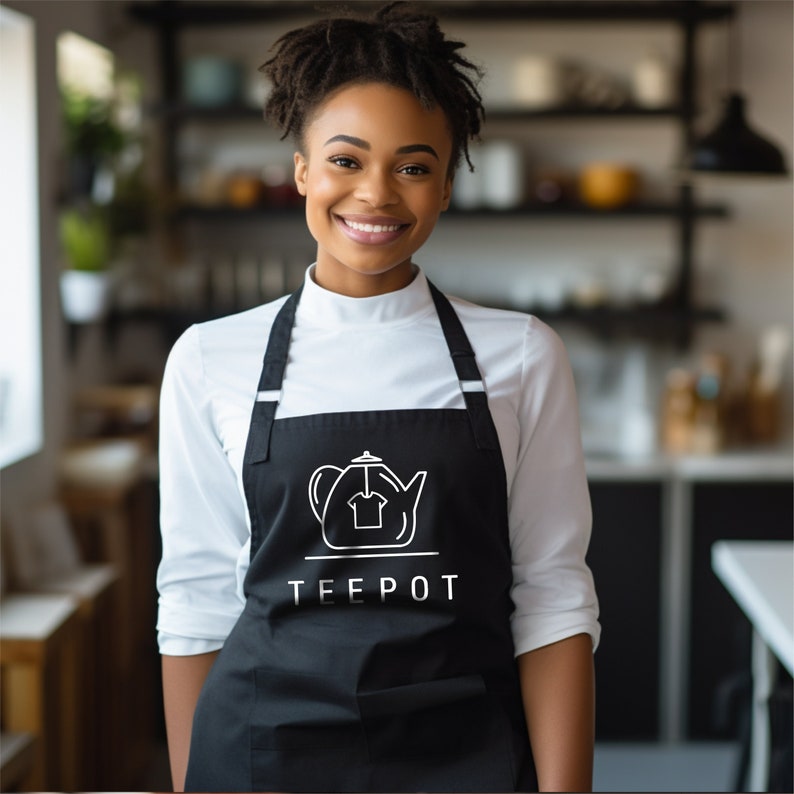 May include: A black apron with white adjustable straps and a white graphic of a teapot with the word "TEEPOT" underneath.