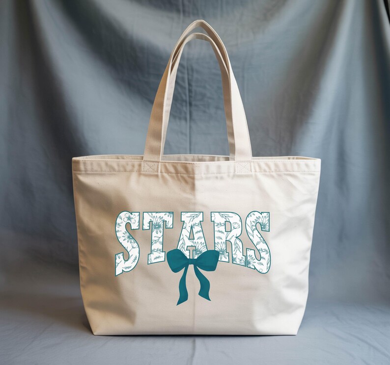 A beige tote bag with the word "STARS" printed on it, along with a blue bow.