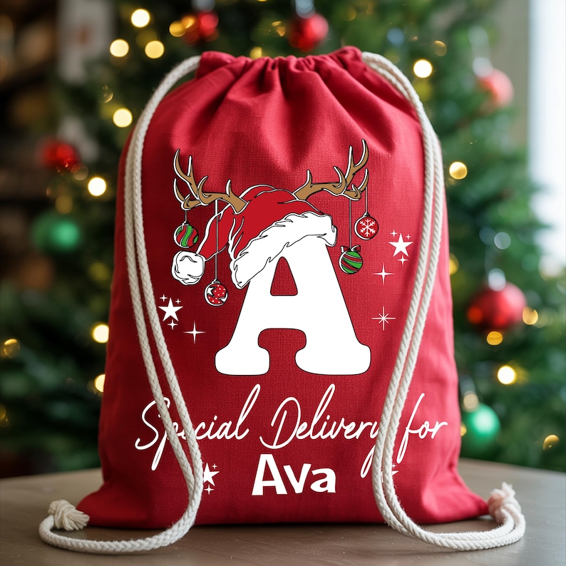 A red drawstring bag with a Christmas tree in the background and a personalized letter "A" on it.