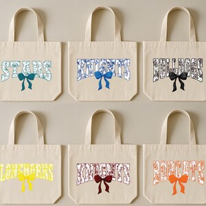 six beige tote bags with various colored bows and text printed on them.