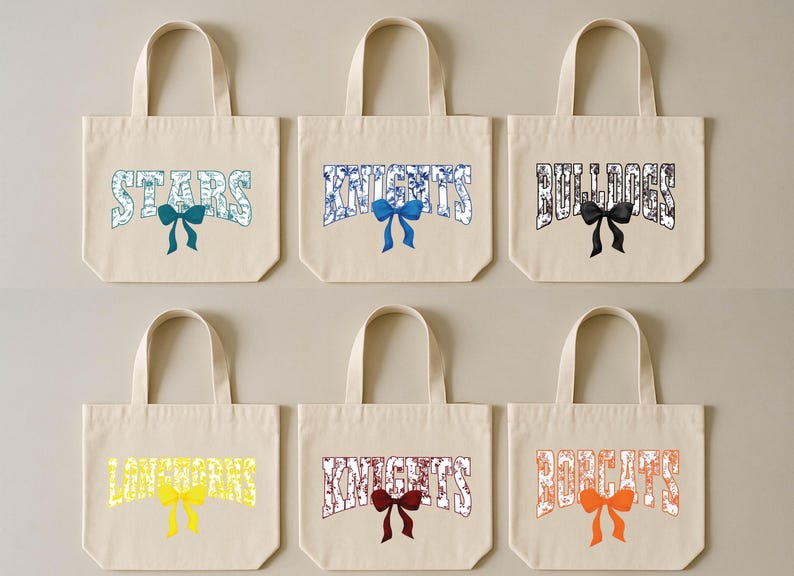 six beige tote bags with various colored bows and text printed on them.