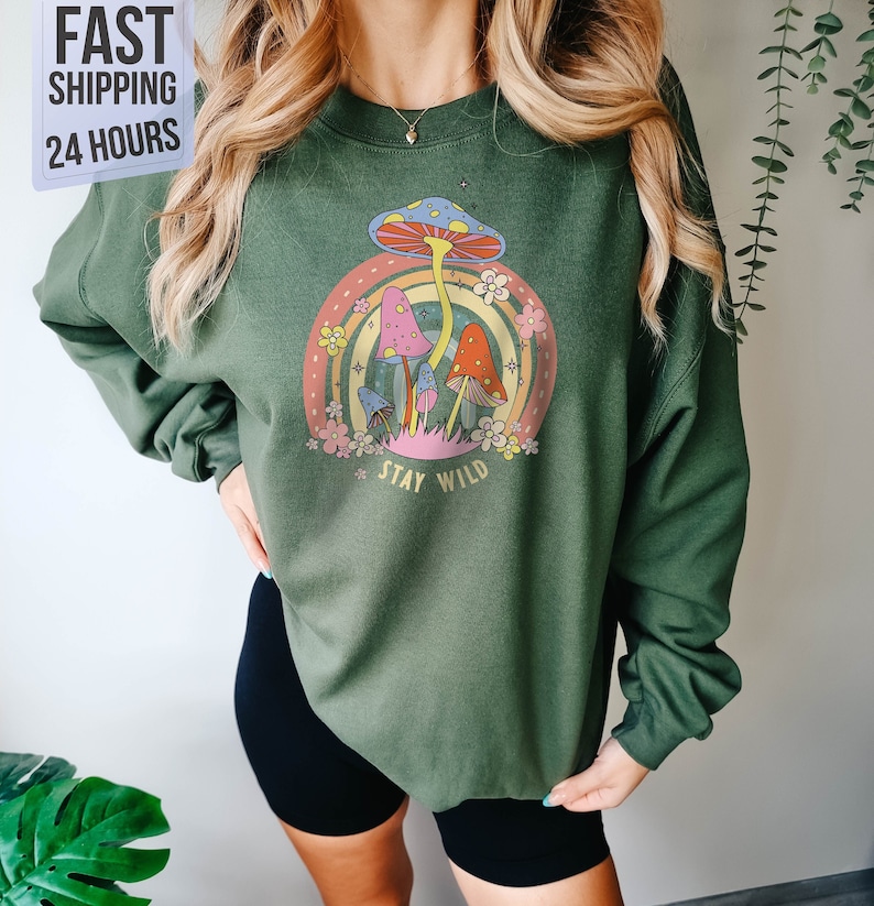 May include: Green sweatshirt with a graphic of colorful mushrooms and a rainbow with the text "Stay Wild".