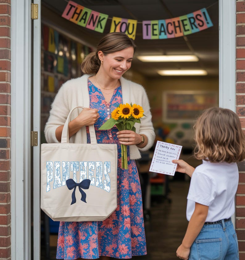 A woman in a floral dress holds a bag with the word "Panthers" and a bouquet of sunflowers, standing in front of a classroom door with a child holding a card.