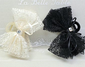 May include: Two lace hair clips, one ivory and one black, each adorned with a sparkling rhinestone and ribbon. The clips have a claw design for secure hold. The background has the text "La Belle Table".