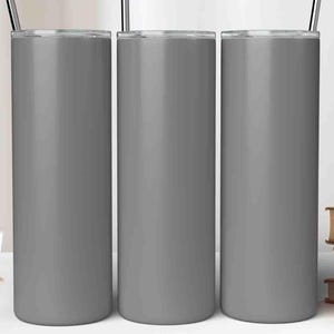 May include: Three gray insulated tumblers with stainless steel straws are displayed on a white surface. The tumblers are cylindrical and have a matte finish. A cup and saucer, plants in decorative pots, and books are also on the surface.