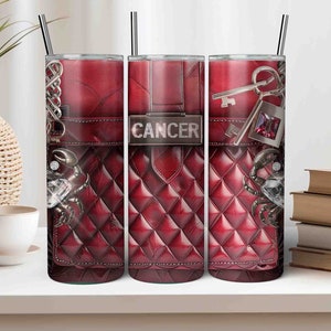 May include: Three stainless steel tumblers with a red quilted design and silver accents. The tumblers feature a key, a crab, and the word "Cancer".