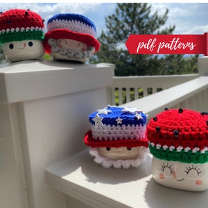 May include: Four crocheted mug toppers in red, white, and blue patriotic colors. The toppers feature a watermelon, a stars and stripes design, and two different styles of Uncle Sam hats. The image includes the text "pdf patterns".