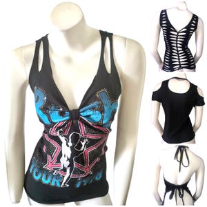May include: Black tank top with a deep V-neck and cut-out shoulder straps. The front features a graphic design with the word "Rush" in blue and a star with a figure. Additional black tops with cut-out and halter designs are also shown.
