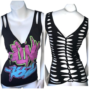 May include: Black sleeveless shirt with a pink, green, and blue graphic print on the front and a cut-out design on the back.