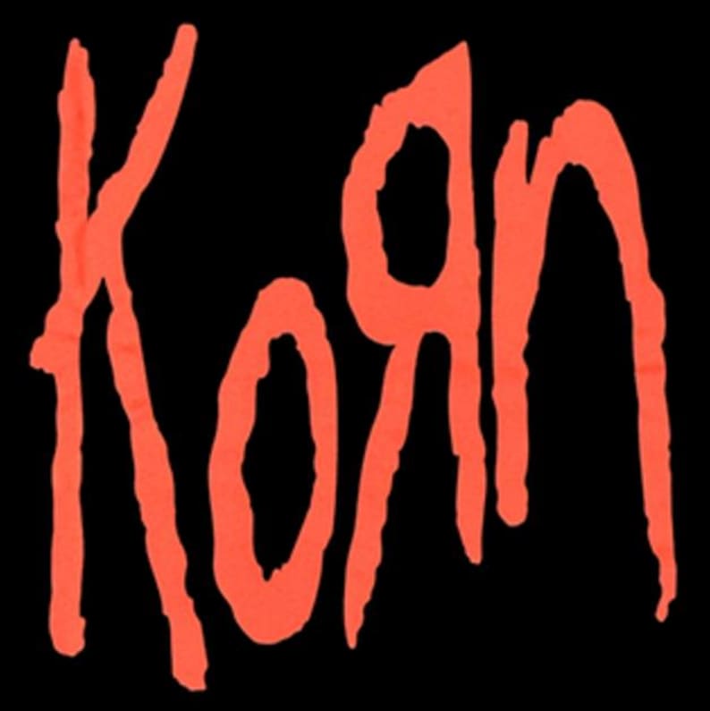 May include: The word "Korn" in bright orange, stylized lettering against a solid black background. The letters appear to have a dripping or textured effect, giving a grunge aesthetic. The design is simple yet bold.