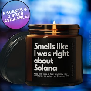 May include: A brown glass candle with a black label that reads "Smells like I was right about Solana". The candle is lit and has a white wick. The label also includes the text "Keep it lit, keep it fast, and may your wallet grow as quickly as Solana's TPS". The candle is 4 ounces.