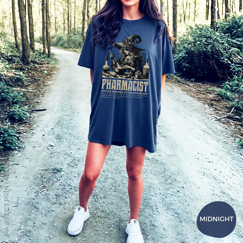 May include: A navy blue t-shirt with a graphic of a witch brewing a potion. The text on the shirt reads "Pharmacist Potion Brewer Extraordinaire".