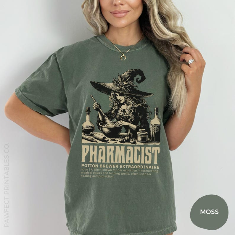 May include: A green t-shirt with a graphic of a witch brewing a potion in a cauldron. The text on the shirt reads "Pharmacist Potion Brewer Extraordinaire noun | A witch known for her expertise in formulating magical elixirs and binding spells, often used for healing and protection."