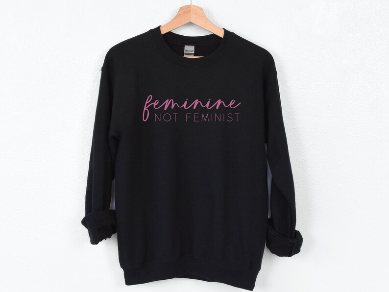 K&ouml;nnte beinhalten: Schwarzer Pullover mit rosa Schriftzug "feminine not feminist".