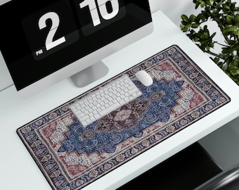 May include: A blue and red patterned desk mat with a white computer keyboard and a white computer mouse on top. The desk mat is on a white desk.