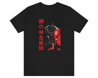 May include: Black t-shirt with a red and black illustration of a character from the anime Fullmetal Alchemist. The Japanese text on the shirt reads "鋼の錬金術師", which translates to "Fullmetal Alchemist".