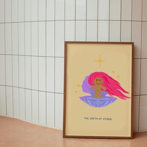 Op de afbeelding: Een ingelijste print met een gele achtergrond met een cartoonillustratie van een troll met roze haar die op een paarse schelp staat. De tekst "The Birth of Venus" staat onder de illustratie.
