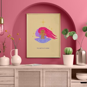 Op de afbeelding: Een digitale illustratie van de geboorte van Venus, een figuur met roze haar dat uit een schelp komt. De illustratie is ingelijst en hangt aan een roze muur boven een houten kast.