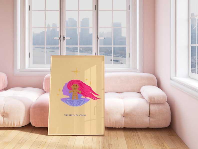 Op de afbeelding: Een digitale illustratie van een trollpop met roze haar die op een paarse schelp zit met een gouden ster erboven. De tekst "THE BIRTH OF VENUS" staat onder de trollpop. De illustratie is ingelijst en hangt aan een muur in een kamer met een roze bank en ramen.