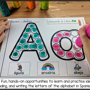May include: A Spanish alphabet learning worksheet with the letter 'A' outlined in black and filled in with green and pink dot stickers. The worksheet also includes the words 'aguila', 'arcoiris', and 'abeja' with illustrations of an eagle, a rainbow, and a bee.