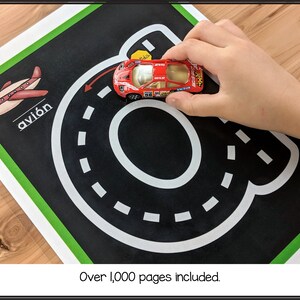 May include: A black and white road track with a red toy car on a green and black background. The Spanish word "avi&oacute;n" is written on the background.