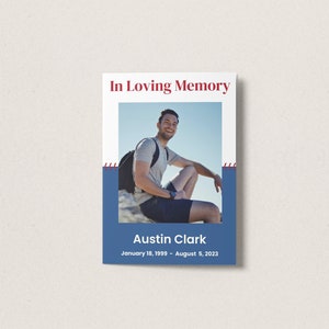 May include: In Loving Memory memorial card with a photo of a man smiling and sitting on a rock. The card is white with a blue border and red stitching. The text on the card reads "In Loving Memory", "Austin Clark", and "January 18, 1989 - August 5, 2023".