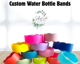 Puede incluir: Una colección de coloridas bandas para botellas de agua en varios tonos, incluyendo rosa, amarillo, azul y verde. Las bandas tienen un diseño ondulado y texturizado y están apiladas. El texto "Custom Water Bottle Bands" se muestra en la parte superior.