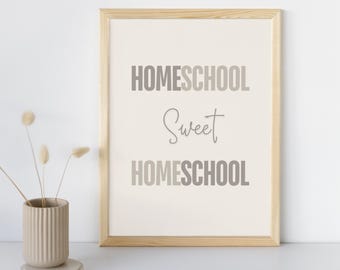 May include: A framed print with the text "Homeschool Sweet Homeschool" in a gray gradient on a white background. The frame is light wood.