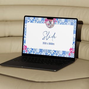 May include: A black laptop displays a presentation slide with a white background, blue and white tile border, and pink floral accents. The slide reads "Slide" in elegant script, with "1920 x 1080px" below. The laptop sits on a beige surface.