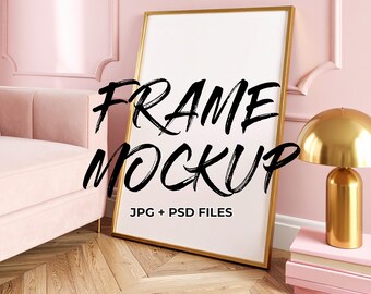 以下が含まれることがあります： 黒い筆記体で「FRAME MOCKUP」と書かれた金色の額縁モックアップ。フレームはピンクの壁に立てかけられています。ピンクのソファ、金のランプ、ピンクの本も画像にあります。
