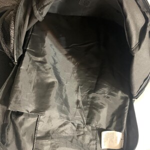 K&ouml;nnte beinhalten: Schwarzer Rucksack mit Rei&szlig;verschluss und einer kleinen Tasche im Inneren. Der Rucksack ist aus strapazierf&auml;higem Stoff gefertigt und hat ein ger&auml;umiges Innenleben.