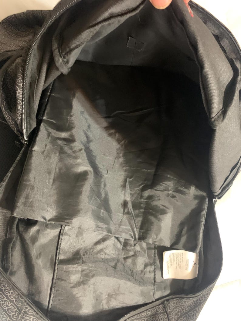 K&ouml;nnte beinhalten: Schwarzer Rucksack mit Rei&szlig;verschluss und einer kleinen Tasche im Inneren. Der Rucksack ist aus strapazierf&auml;higem Stoff gefertigt und hat ein ger&auml;umiges Innenleben.