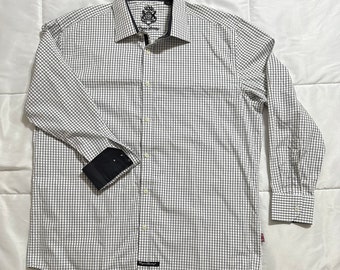 May include: A white long-sleeve button-down shirt with a black and white checkered pattern. The shirt has a black collar and cuffs. The shirt has a small logo on the left side of the chest.
