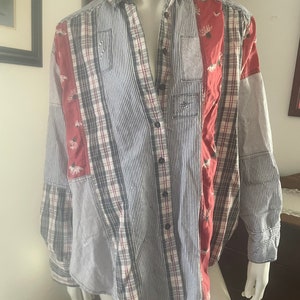Pode incluir: Uma camisa de manga comprida com bot&otilde;es e design de patchwork. A camisa &eacute; feita de uma variedade de tecidos, incluindo xadrez, listras e cores s&oacute;lidas. A camisa tem um caimento solto e uma gola.