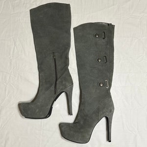 May include: A pair of gray suede knee-high boots with a platform heel and a zipper on the inside of the boot.