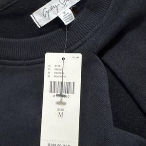 May include: Black sweatshirt with a white tag that says "Grey State" and a price tag that says "$138.00 USD $158.00 CAD". The tag also says "Size M" and has a barcode.
