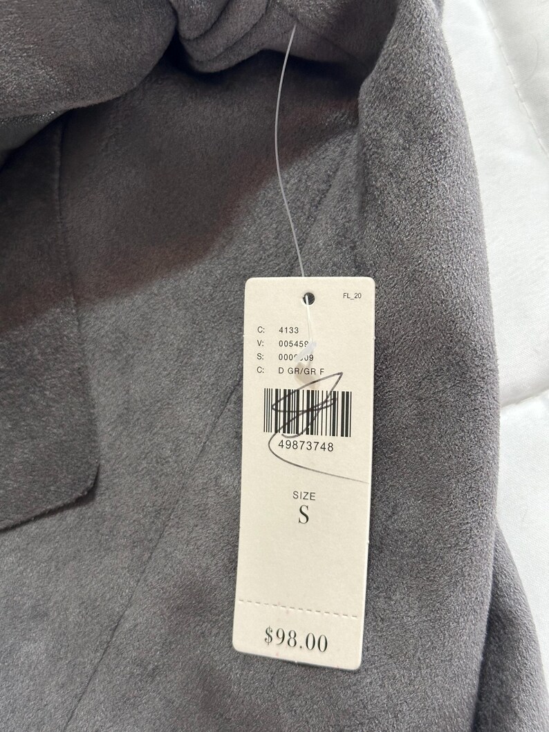 Pu&ograve; includere: Un blazer grigio con un'etichetta attaccata. L'etichetta include la taglia "S" e il numero "49873748". Il blazer &egrave; realizzato in un materiale morbido e ha un design classico.