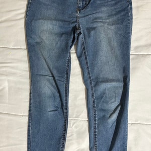May include: A pair of blue denim jeans with a faded wash. The jeans have a slim fit and a mid-rise waist.