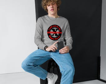 May include: A gray long-sleeve shirt with a circular graphic that reads "I will not be the GENERATION Bigger Person" in red and white. The shirt is paired with blue jeans and white sneakers.