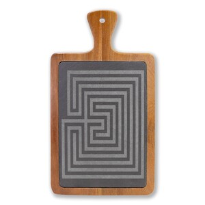 Peut inclure: Planche de service en bois avec une poignée. Elle présente un insert en ardoise gris foncé avec un motif de labyrinthe géométrique. Le bois a une finition naturelle. Idéale pour servir des apéritifs ou de la charcuterie.