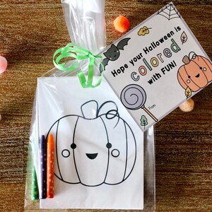 May include: A clear plastic bag filled with a coloring page of a pumpkin with a happy face, four crayons, and a card that says "Hope your Halloween is colored with FUN!"