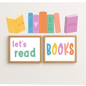 May include: Two framed prints with the words "let's read" and "BOOKS" in colorful letters. Above the frames are cartoon illustrations of books in various colors, including yellow, blue, pink, orange, and green. The image is set against a white background.