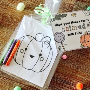 May include: A clear plastic bag filled with a coloring page of a pumpkin with a cute face and four crayons. The bag also includes a small card with the text "Hope your Halloween is colored with FUN!" and a small illustration of a bat, a lollipop, and a pumpkin.