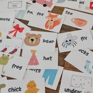 May include: A set of flashcards with various images and words, including animals, insects, clothing, and household items. The words include "bee", "goose", "mail", "tea", "pa, fox", "ants", "bear", "frog", "hat", "fly", "socks", "make", "chick", "under", "crow".