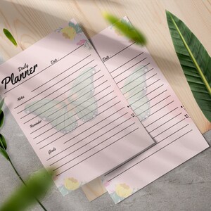 May include: Two pink daily planner pages with a butterfly design and floral accents. The text "Daily Planner" is at the top of the page.