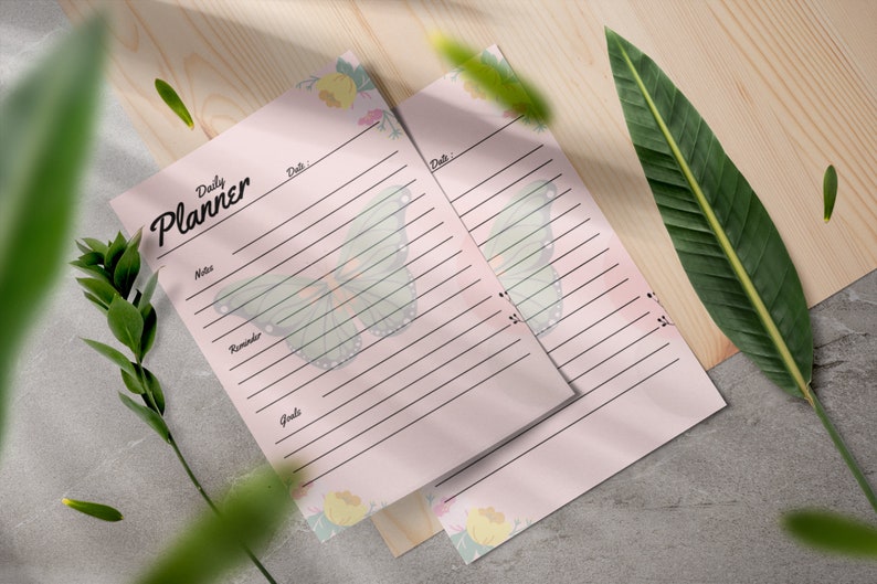 May include: Two pink daily planner pages with a butterfly design and floral accents. The text "Daily Planner" is at the top of the page.