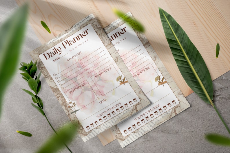 Puede incluir: Dos p&aacute;ginas de planificador diario imprimibles con un dise&ntilde;o floral. Las p&aacute;ginas incluyen secciones para listas de tareas, recordatorios, prioridades, objetivos y un rastreador de agua.