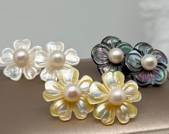 May include: Three pairs of flower-shaped stud earrings crafted from iridescent shell material. Each earring features a central round white pearl. The set includes one pair of white shell flowers, one pair of yellow shell flowers, and one pair of dark gray shell flowers.