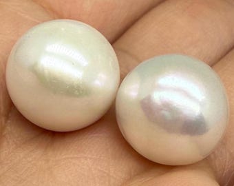 May include: Two round, lustrous white pearls with a smooth, reflective surface. Each pearl exhibits a subtle iridescent sheen, highlighting the natural nacre texture. The pearls are spherical in shape, displaying a bright, clean appearance.