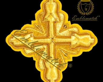 May include: A gold embroidered cross with intricate details. The cross is made of a thick, golden thread and has a raised design. The cross is surrounded by a yellow background.